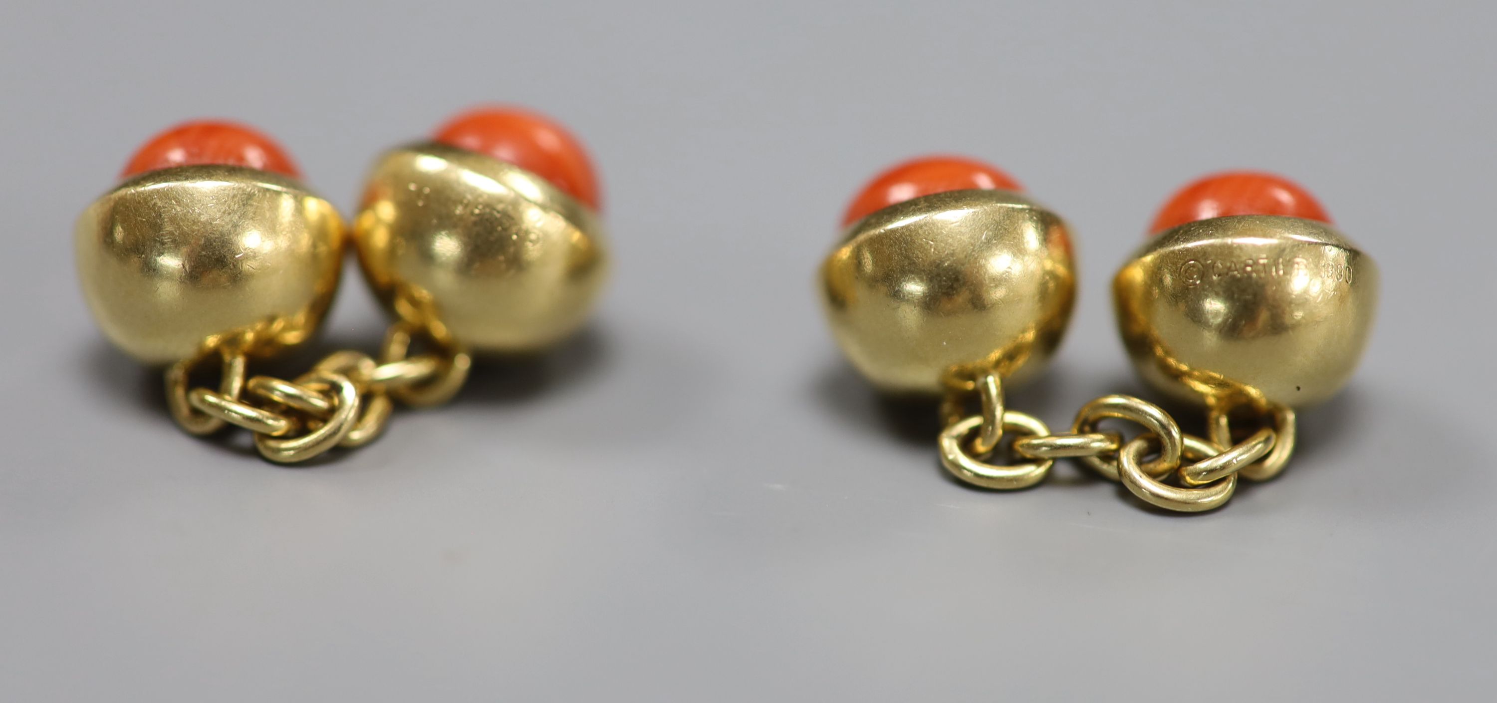 A pair of Cartier 750 yellow metal and coral bead set spherical cufflinks,